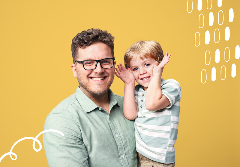  A father and son smile at each other.