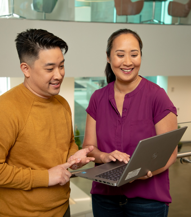  Two people are looking at a laptop together.