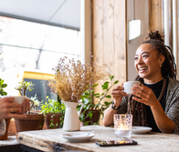 Two businesswomen talking while having a coffee at restaurant.