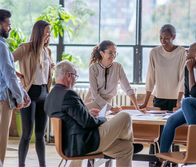  A group of multi-ethnic business professionals are having a casual meeting in an office space.