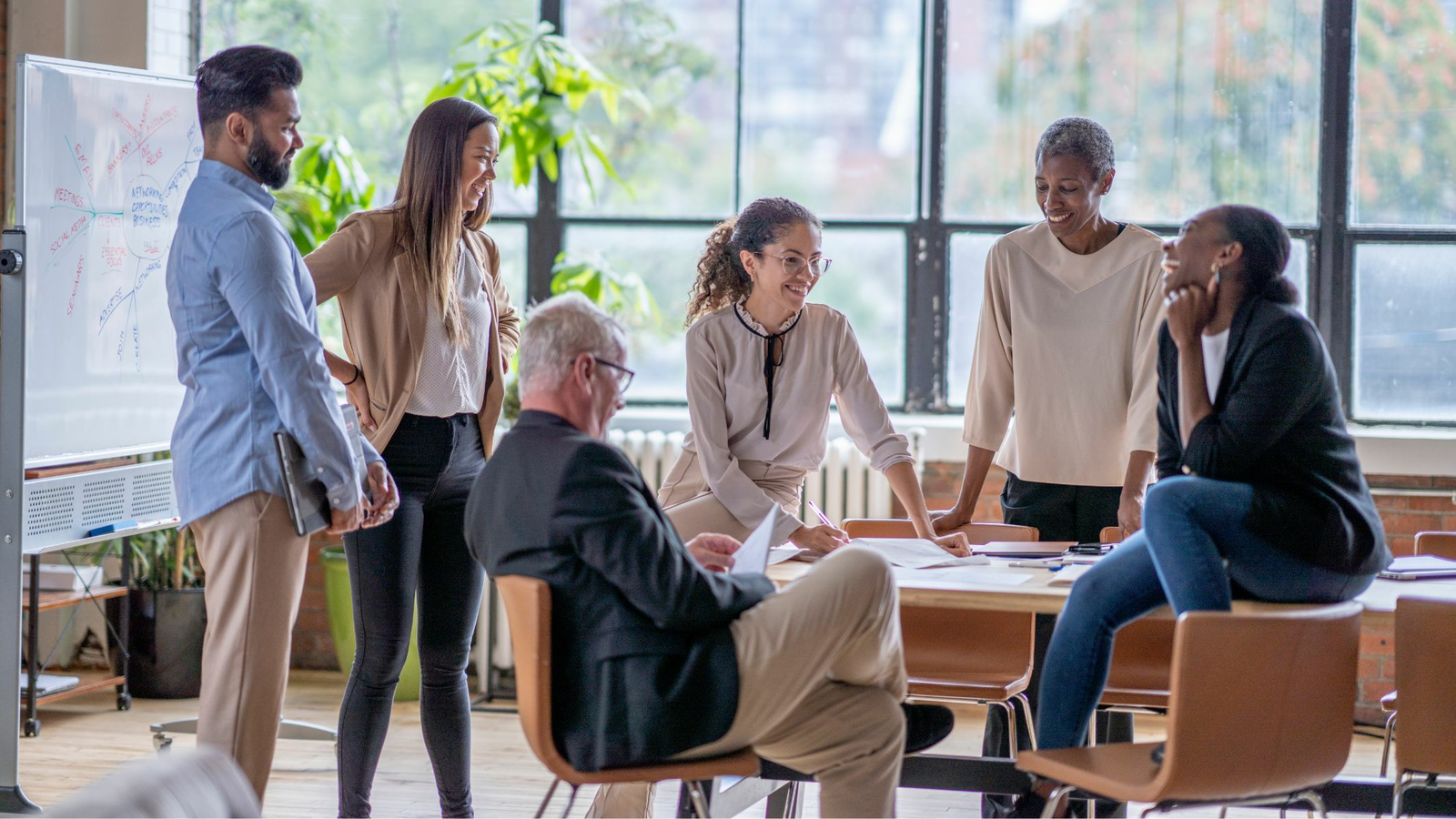  A group of multi-ethnic business professionals are having a casual meeting in an office space.