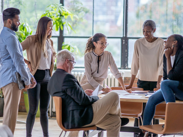  A group of multi-ethnic business professionals are having a casual meeting in an office space.