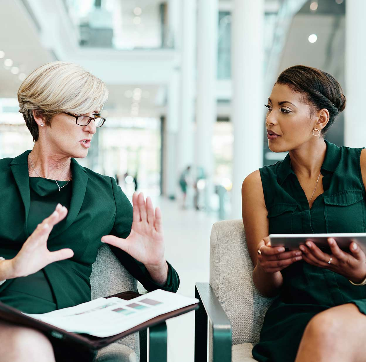 Two business women in an office space, discussing strategy