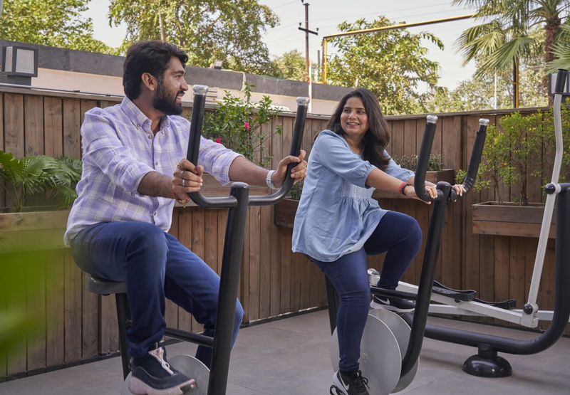  A man and a woman are exercising on stationary bikes.