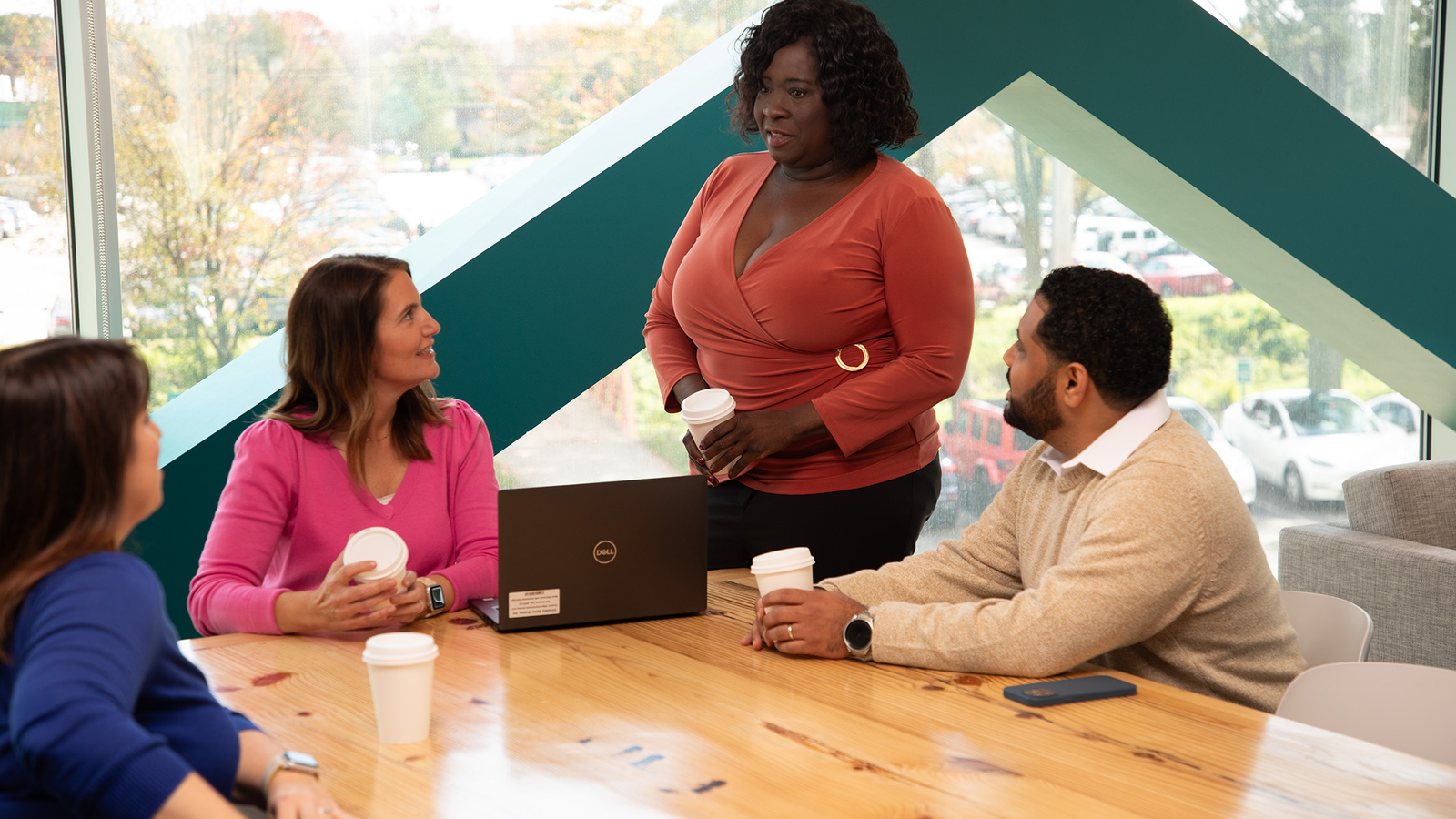  Four people are sitting around a table having a meeting.