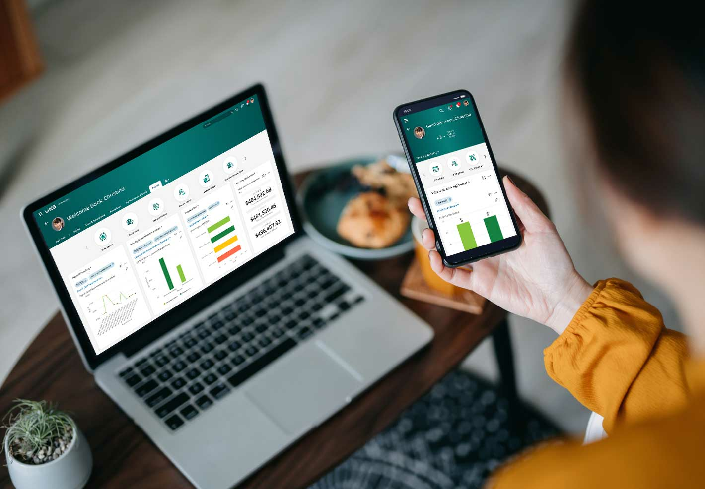 UKG HR and payroll software on a laptop and mobile display