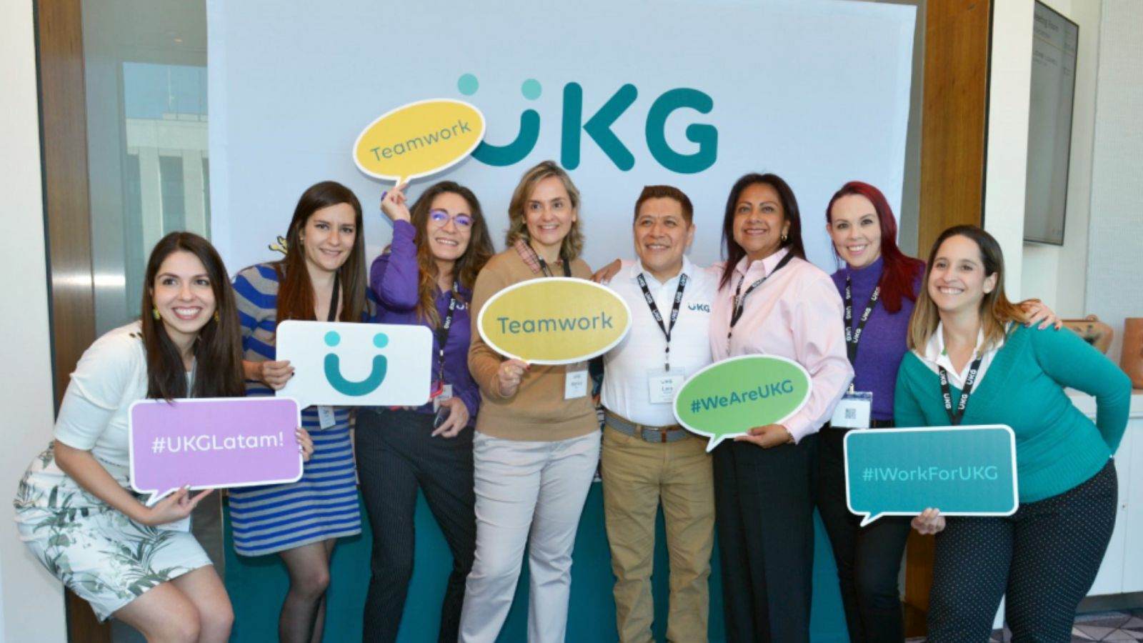 A group of seven women are posing for a photo at a conference.