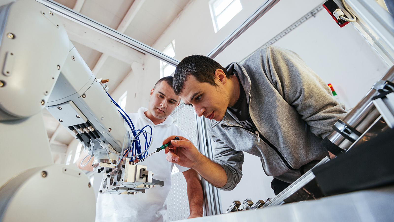  Two engineers work on a robotic arm.