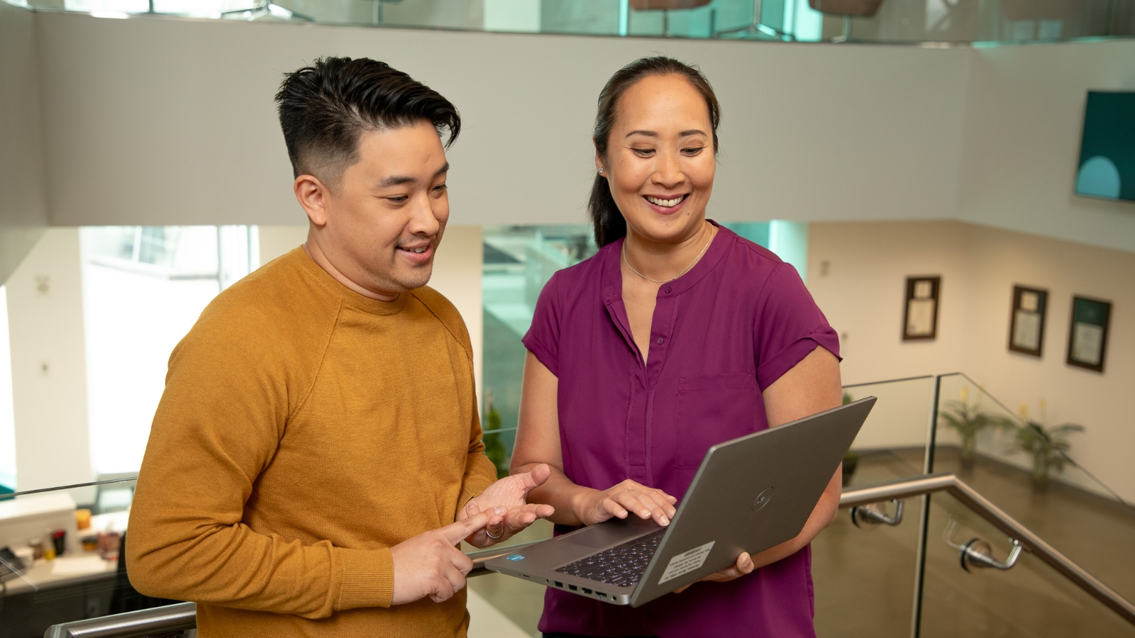  Two people are looking at a laptop together.