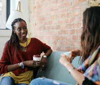 two women talking and drinking coffee